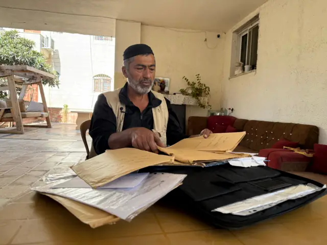 الفلسطيني عوض حزمة يعرض أوراقه التي قدمها للذهاب إلى الولايات المتحدة