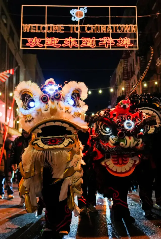 Dancers wear lion costumes to perform during midnight Lunar New Year celebration for New York Chinatown