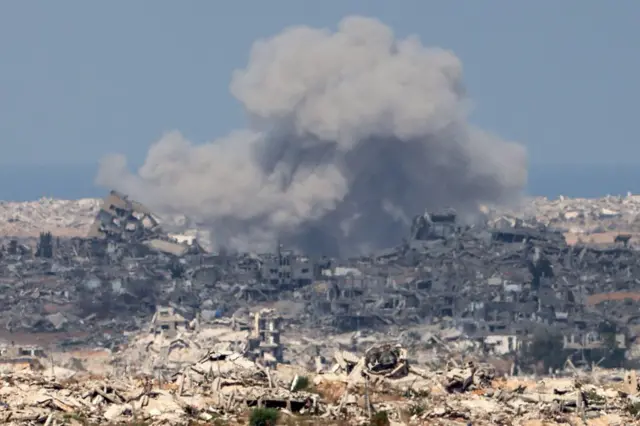 Smoke billows folllowing an explosion and the ruins of dozens of buldings can be seen in all directions 