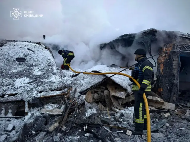 Пожежники на засніжених руїнах