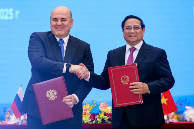 Thủ tướng Việt Nam Phạm Minh Chính (phải) và Thủ tướng Nga Mikhail Mishustin (trái) bắt tay nhau trong lễ ký kết tại Văn phòng Chính phủ tại Hà Nội vào ngày 14/1/2025