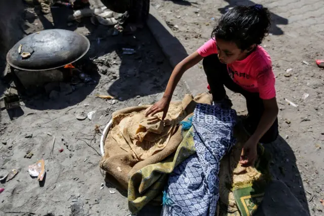 طفلة في قطاع غزة تتناول خبزاً طُهي على موقد نار بسبب نفاد الوقود والغاز