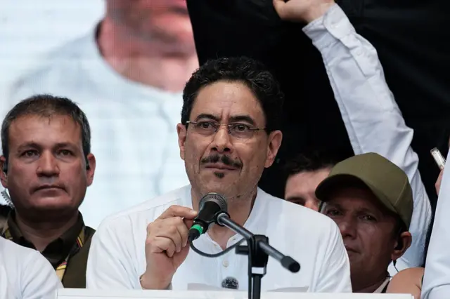 Iván Cepeda frente a un micrófono rodeado de gente