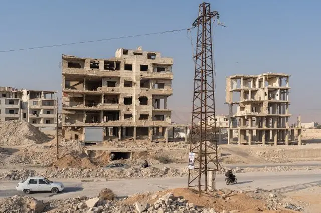 Suriye'nin Şam şehrinin dışındaki Harasta'da bir elektrik kulesinin yakınındaki yıkılmış binalar. 19 Ocak 2025.