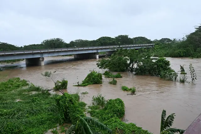 Road wey dey flooded almost reach di bridge for Jamaica