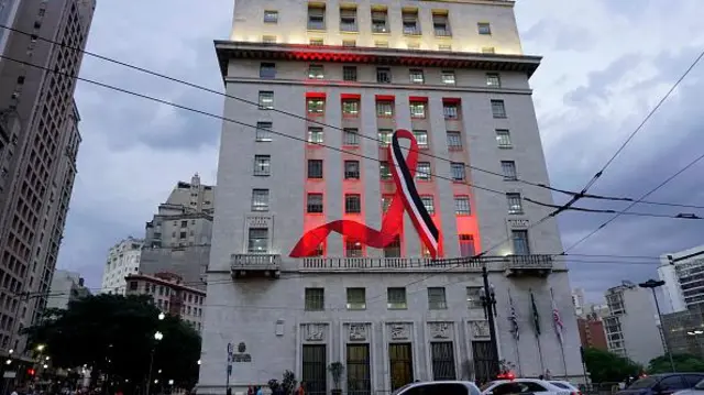 Grande laço nas cores preto, vermelho e branco estendidobet scoreprédio