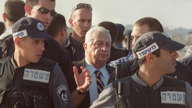 O então primeiro-ministro de Israel Ariel Sharon cercado por policiais ao deixar a mesquita de al-Aqsa, em 2000