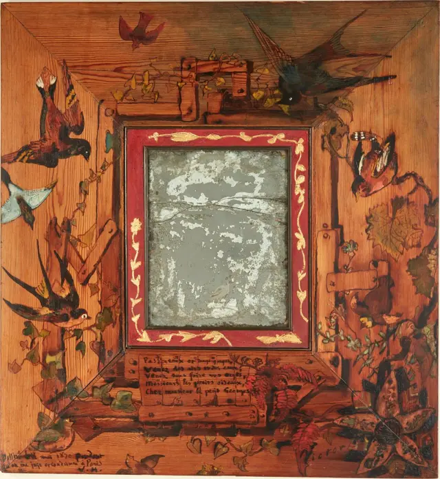 Un espejo, ya degradado, con un ancho marco pintado con fondo terracota, pájaros y plantas. ("Espejo con pájaros", 1870. Marco de madera pintado a mano e inscrito, pintura al óleo, barniz, 70 x 65 cm. Maisons de Victor Hugo, París / Guernsey).