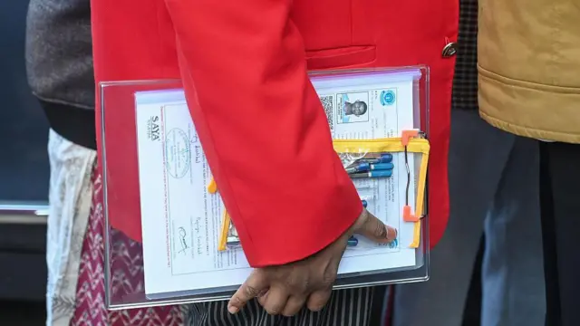 बोर्ड और पेन लिए एक स्टूडेंट