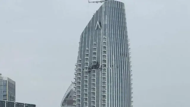 Фотография высотного здания в Дубае с повреждением фасада на верхних этажах.