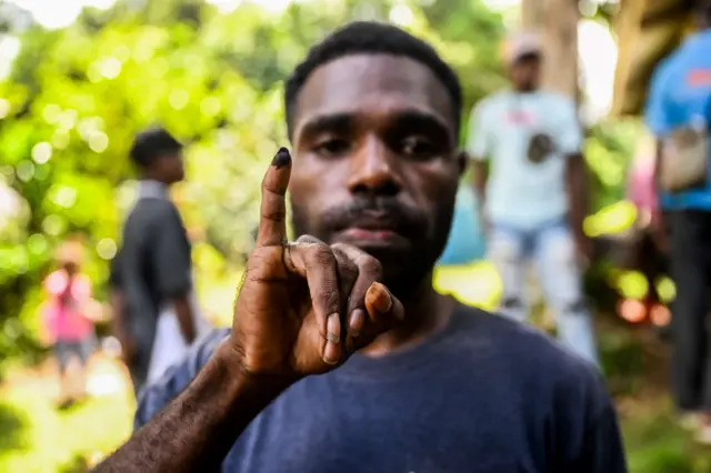 Seorang warga menunjukkan jari yang tercelup tinta tanda hak suaranya telah diberikan dalam Pilkada 2024 di salah satu TPS di wilayah masyarakat adat Knasaimos, Distrik Saifi, Kabupaten Sorong Selatan, Papua Barat Daya, Rabu (27/11/2024).