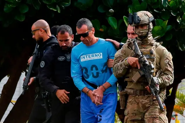 O líder da organização criminosa brasileira Primeiro Comando da Capital (PCC), Marcos Camacho, conhecido como Marcola, é escoltado antes de embarcar em um helicóptero após receber atendimento médico em um hospital em Brasília, em janeiro de 2020