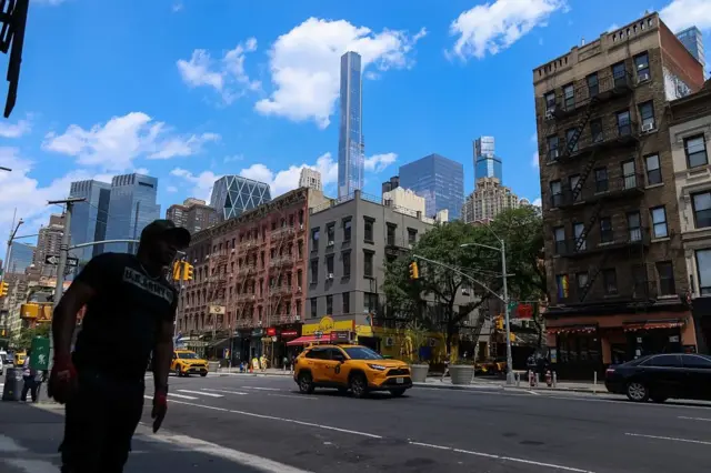 Нью-Йорк кўчаларидан бирида кетаётган одам.