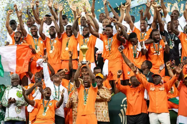 L'attaquant ivoirien n°15 Max-Alain Gradel (C) soulève le trophée de la Coupe d'Afrique des Nations sur le podium après que la Côte d'Ivoire a remporté la finale de la Coupe d'Afrique des Nations (CAN) 2024 entre la Côte d'Ivoire et le Nigeria au stade olympique Alassane Ouattara d'Ebimpé, Abidjan, le 11 février 2024.