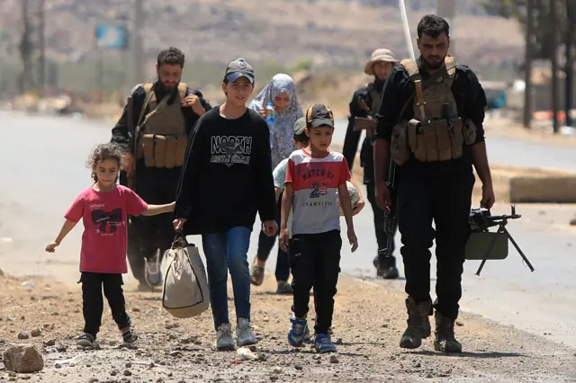 Suriyeli askerler Süveyda'dan bir aileye vilayet dışına kadar eşlik ediyor.