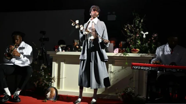 Wata mata a tsaye da tufafin ƙawa
