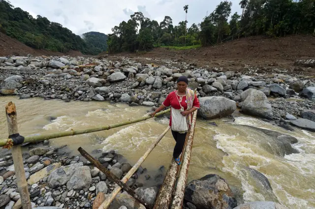 Warga menyeberangi jembatan darurat di atas aliran Sungai Nanggang, Jorong Gumarang II, Nagari Tigo Koto Silungkang, Palembayan, Agam, Sumatera Barat, Kamis (4/12/2025).