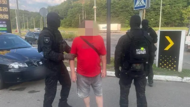 поліція і чоловік в червоній футболці, його обличчя розмите