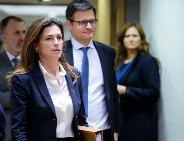 Judith Varga, en primer plano, con otras personas en un un pasillo de Bruselas.