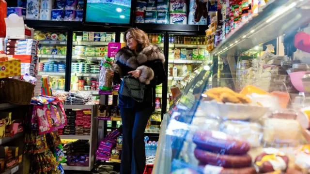 इस्तंबूलमधील बाजारात एक महिला काही किराणा सामान खरेदी करत आहे 