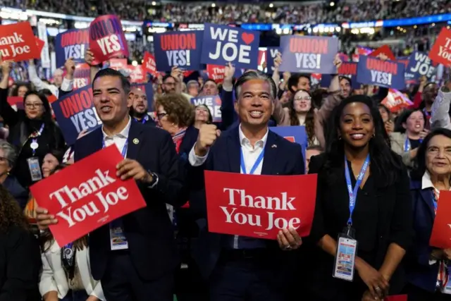 Participantes de la Convención Nacional Demócrata sostienen carteles en agradecimiento al presidente Joe Biden en Chicago, Illinois, Estados Unidos, el 19 de agosto de 2024.