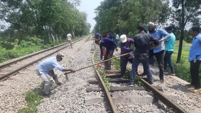 বেঁকে যাওয়া রেল লাইন ঠিক করার চেষ্টা করছেন রেল কর্মীরা