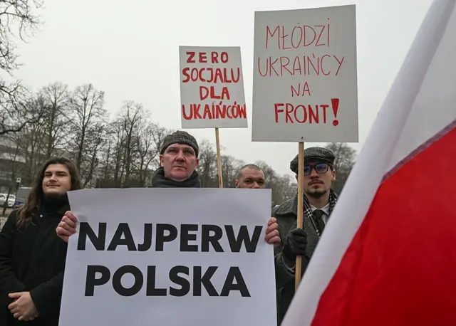 Поляки з антиукраїнськими плакатами та польськими прапорами
