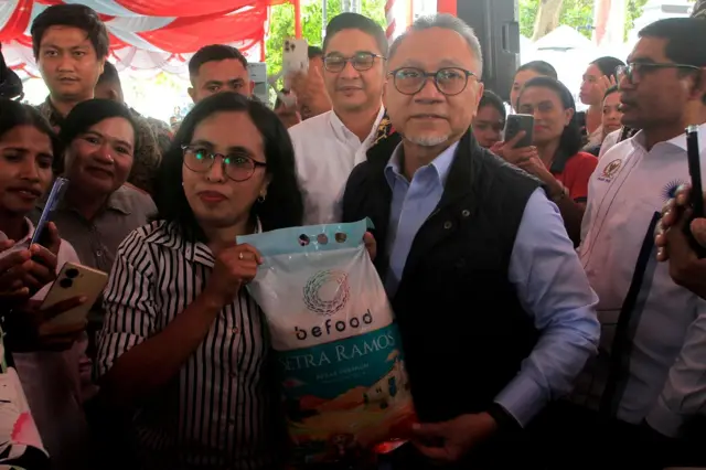 Menteri Koordinator Bidang Pangan Zulkifli Hasan (kedua kanan) menyerahkan secara simbolis satu karung beras kepada warga saat kunjungan kerja ke Gereja Bethel Indonesia (GBI) Nusa Tenggara Timur di Kota Kupang, Provinsi Nusa Tenggara Timur, Jumat (15/05).