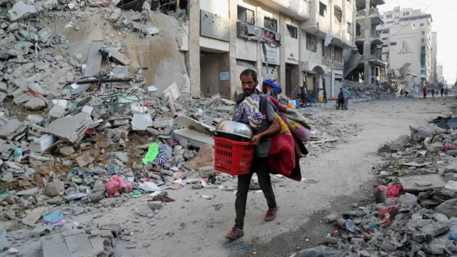 Palestyńczyk niesie swój dobytek podczas izraelskiej operacji wojskowej po tym, jak mieszkańcom wydano nakaz ewakuacji miasta Gaza