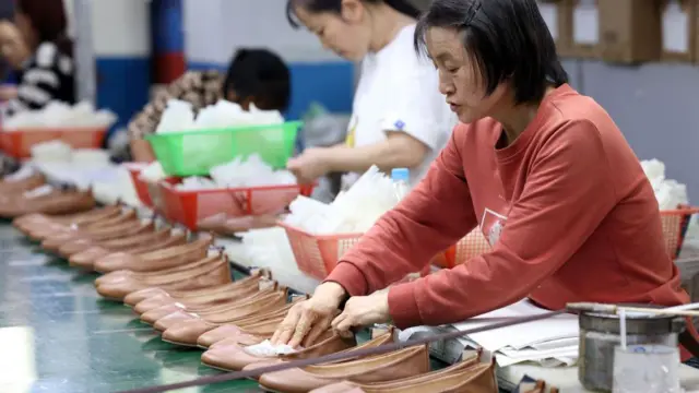 Pekerja produsen sepatu kulit berorientasi ekspor sedang melakukan aktivitas di pabrik sepatu Fujian Tenglong Shoe Industry Co Ltd pada 4 Juni 2024 di Fuzhou, Provinsi Fujian, China