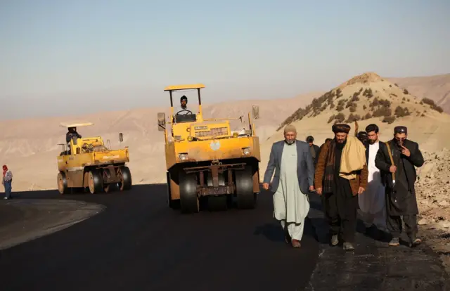 مردان در کنار ماشین‌های غلتک 