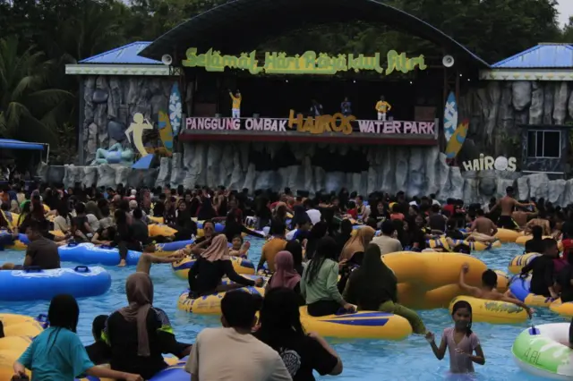 Ribuan warga berenang saat hari libur sekolah.