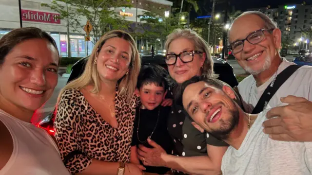 Claudia Rodríguez, sonríe a cámara en una selfie en la que también se ve a miembros de su familia.