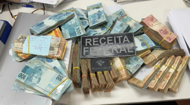 Bolo de várias notas de cem, cinquenta e dez reais apreendidos na Operação Fluxo Oculto