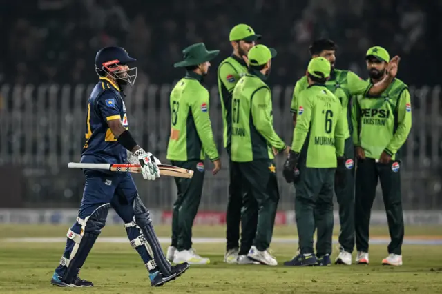 පකිස්ථානය සහ ශ්‍රී ලංකාව අතර පළමු එක්දින ක්‍රිකට් තරගයේදී කුසල් මෙන්ඩිස් දැවී යාමෙන් පසු ක්‍රීඩාගාරය වෙත පිය නගන අයුරු. පසුපසින් පකිස්ථාන ක්‍රීඩකයින් හය දෙනෙක් සිටිති.