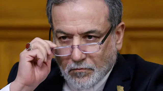 Глава МИД Ирана Аббас Арагчи, лицо крупно, смотрит поверх очков