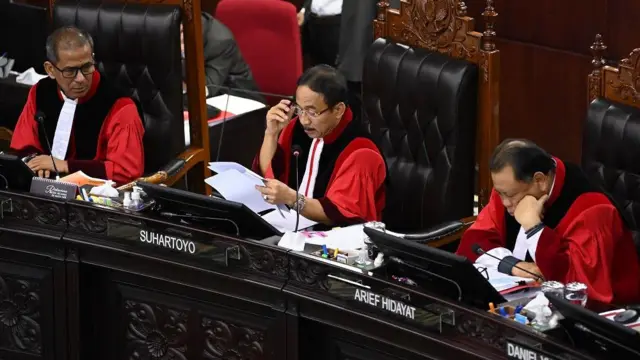Ketua Mahkamah Konstitusi (MK) Suhartoyo (tengah) didampingi Hakim Konstitusi Saldi Isra (kiri) dan Arief Hidayat (kanan) membacakan putusan saat sidang putusan perselisihan hasil Pilpres 2024 di Gedung Mahkamah Konstitusi, Jakarta, Senin (22/4/2024). 