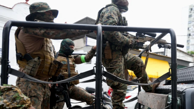 Трое вооруженных мужчин в камуфляже со скрытыми лицами в кузове грузовика