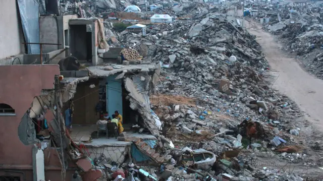 عائلة فلسطينية تتناول وجبة الإفطار في منزلها المدمر وسط أنقاض المباني في بيت لاهيا شمال قطاع غزة في 4 مارس 2025، خلال شهر رمضان المبارك.