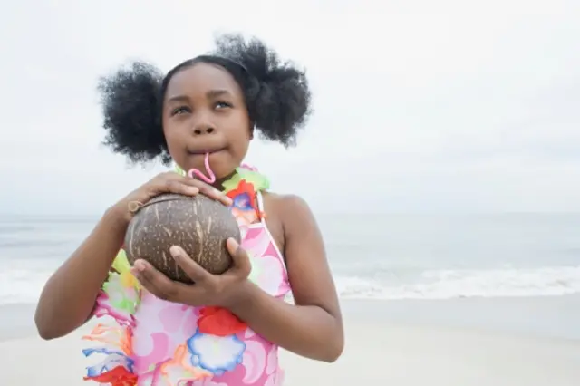 Petite fille qui boit de l'eau de coco