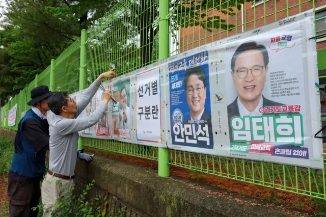 경기도선거관리위원회 직원들이 제9회 전국동시지방선거 공식 선거운동이 시작된 21일 경기 수원시 팔달구 율현중학교 펜스에 경기도지사, 수원시장, 도의원, 시의원, 경기도교육감 후보 선거벽보를 첩부하고 있다