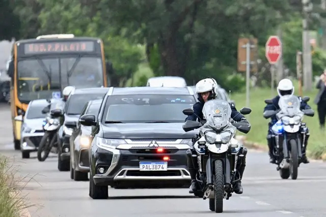 Carro sendo escoltado por motos da polícia