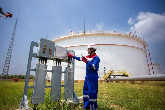 Seorang pekerja berada di sekitar tangki BBM