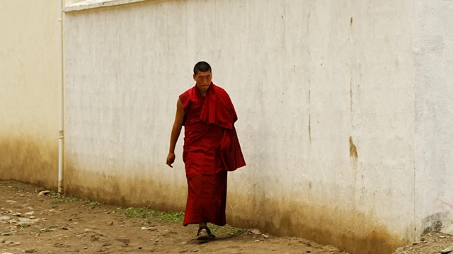Un monje caminando por una calle.