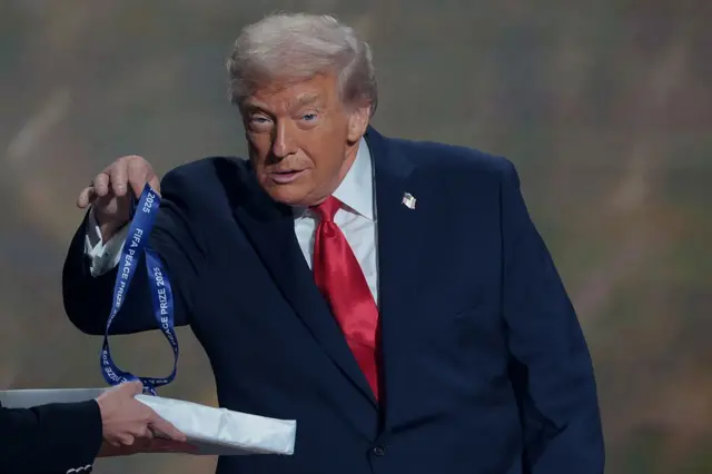 ABD Başkanı trump verilen madalyayı sallarken. 