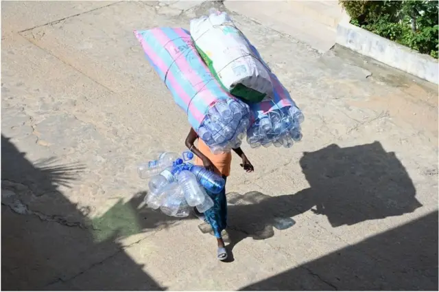 A woman in Abidjan, Ivory Coast, carries an impressive number of water bottles on her head on Tuesday.