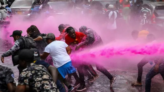 Des manifestants (C) sont repoussés par un canon à eau qui tentait de les disperser alors qu'ils participaient à une manifestation contre un projet de loi fiscale controversé dans le quartier central des affaires de Nairobi, au Kenya, le 20 juin 2024. 