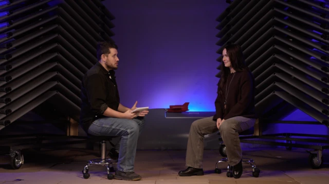 Чоловік і дівчина спілкуються сидячі в цеху