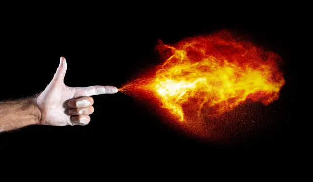 Foto tangan yang mengeluarkan api.