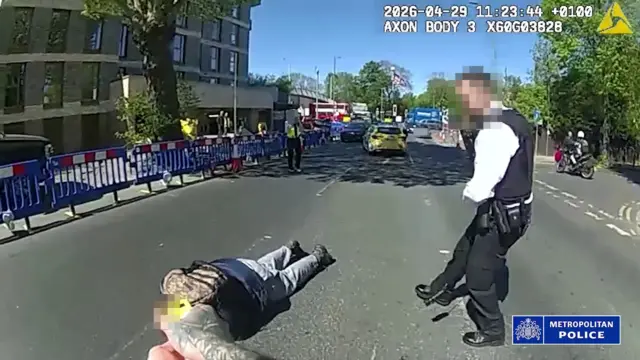 Metropolitan Polis Teşkilatı tarafından yayınlanan, polis memurlarının üzerlerinde taşıdıkları kameralardan alınan ekran görüntüsünde, 45 yaşındaki bir adamın polis memurları tarafından durdurulup tutuklandığı görülüyor; adam halen gözaltında tutuluyor.
